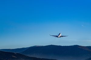 Aircraft taking off over a mountain range in the distance