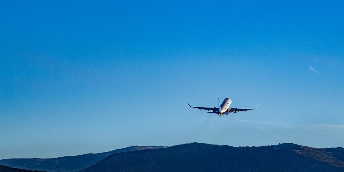 Aircraft taking off over a mountain range in the distance