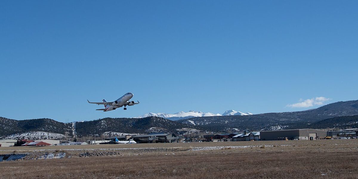 Plane taking off over mountainous runway